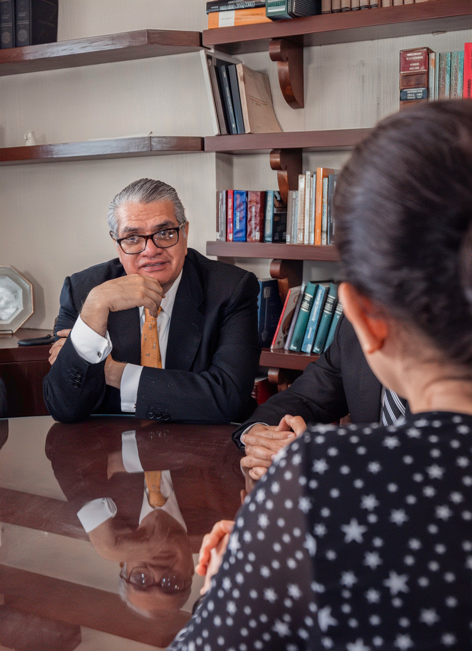 Abogados del despacho en sesión de trabajo con una clienta