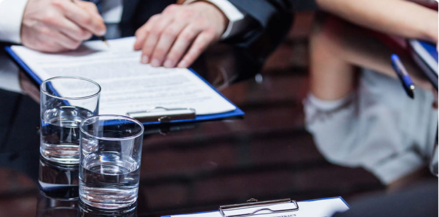 Firma de documentos en una mesa de junta